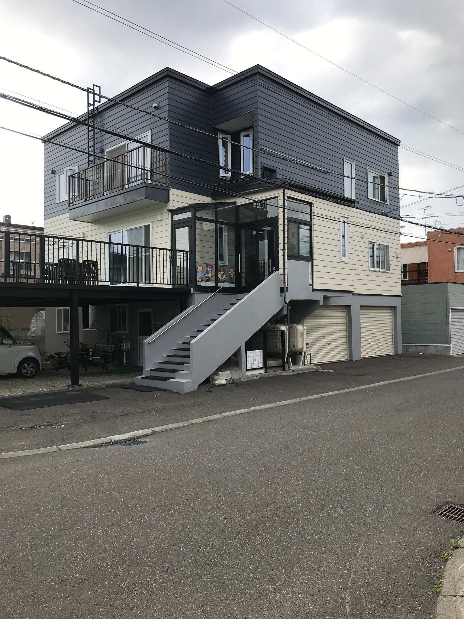 外壁の塗り替え後。濃いグレーと明るい色のツートーンになった建物